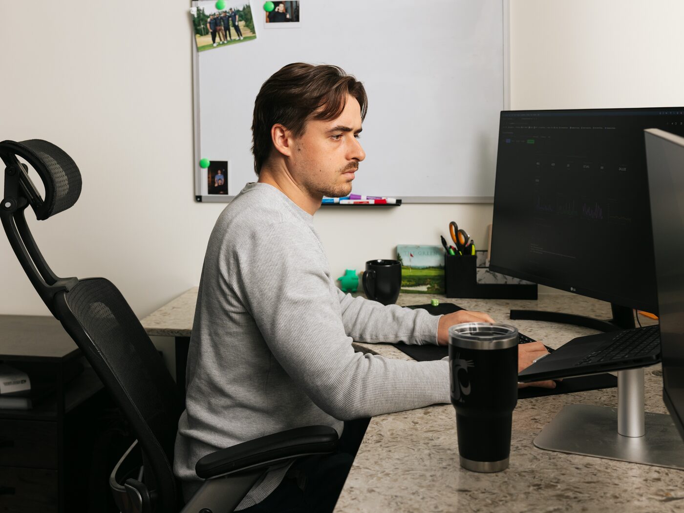 Dylan Axelson working at his desk with an SEO planning whiteboard behind him