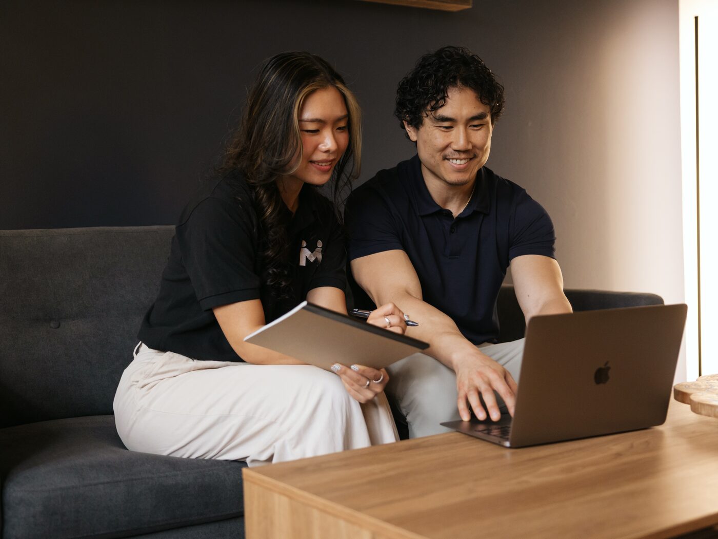 Vivian Liu reviewing work with a teammate on the studio sofa