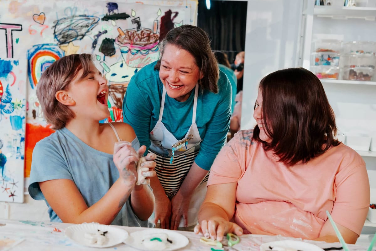People at table doing crafts in colorful creative environment